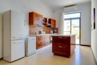 a kitchen with white appliances and a large window at Modern 2 Bedroom Maisonette in Central Sliema in Sliema