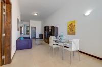 a dining room and living room with a table and chairs at Modern 2 Bedroom Maisonette in Central Sliema in Sliema
