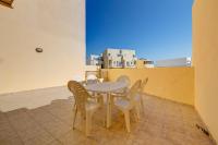 a table and chairs on a balcony with a view at Modern 2 Bedroom Maisonette in Central Sliema in Sliema