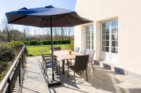 a table and chairs with an umbrella on a patio at Jolie maison pour 8 personnes in Plobannalec-Lesconil