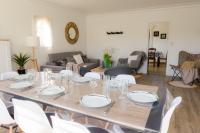 a dining room with a table and white chairs at Jolie maison pour 8 personnes in Plobannalec-Lesconil