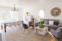 a living room with a couch and a table and chairs at Jolie maison pour 8 personnes in Plobannalec-Lesconil