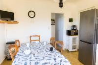 a dining room with a table and a refrigerator at Jolie maison pour 8 personnes in Plobannalec-Lesconil