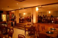 un ristorante con tavoli e sedie in legno e persone che mangiano di Hotel Aurora a Marina di Cecina