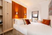 Un dormitorio con una gran cama blanca en una habitación. en The Snug Townhouse, en Galway