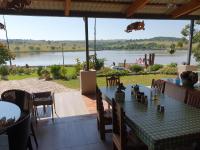 MatsaphaGoggas Nest BNB & Restaurant的湖景用餐室配有桌子