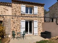 eine Terrasse mit Stühlen und einem Tisch vor einem Gebäude in der Unterkunft Cottage les Marjoris Tanneron in Tanneron