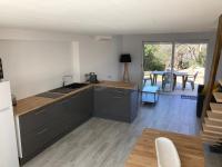 eine Küche mit schwarzen Schränken und ein Esszimmer in der Unterkunft Cottage les Marjoris Tanneron in Tanneron