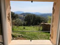 ein Fenster mit Blick auf ein Feld und Berge in der Unterkunft Cottage les Marjoris Tanneron in Tanneron