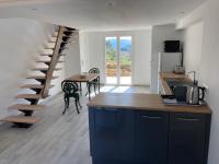 eine Küche mit einer Wendeltreppe und einem Tisch mit einem Esszimmer in der Unterkunft Cottage les Marjoris Tanneron in Tanneron