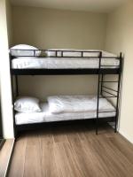 two bunk beds in a room with white sheets at Residentie Zeezicht in Eksel