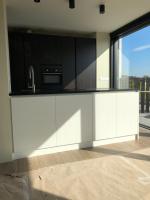 a kitchen with black and white cabinets and a microwave at Residentie Zeezicht in Eksel