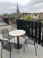 a table and chairs on a balcony with a view at Residentie Zeezicht in Eksel