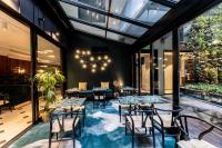 Un restaurante con mesas, sillas y ventanas. en Hotel Parister Piscine & Spa, en París