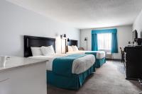 Dos camas en una habitación de hotel con cortinas azules. en Ramada by Wyndham Surrey&#47;Langley, en Surrey