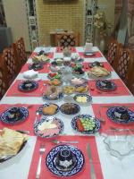 a long table with plates of food on it at Shodlik Guest House in Khiva