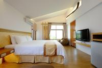 a bedroom with a large bed and a television at Cloud Inn in Hengchun South Gate