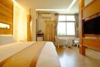 a bedroom with a bed and a flat screen tv at Cloud Inn in Hengchun South Gate