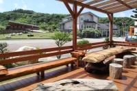 a wooden deck with benches and a picnic table at Star-Moon B&amp;B Green Island in Green Island