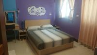a bedroom with a bed with a purple wall at The Beauty of Basalt B&amp;B in Magong
