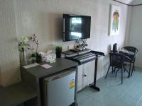 a kitchen with a counter and a tv on the wall at Samui Green Hotel in Chaweng