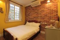 a bed in a room with a brick wall at Beautiful Life B&amp;B in Dongshan