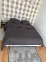 a bed with a black comforter in a bedroom at Studio indépendant Lisieux in Lisieux