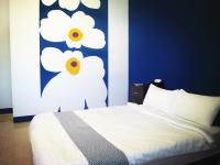 a bedroom with a white bed with a blue wall at Camellia B&amp;B in Taitung City