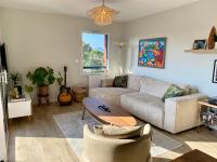 sala de estar con sofá y mesa en Superbe appartement, grande terrasse vue mer et montagne, en San Juan de Luz