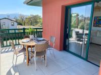 una mesa y sillas en un patio con balcón en Superbe appartement, grande terrasse vue mer et montagne, en San Juan de Luz