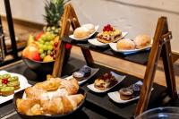 a table topped with plates of pastries and fruit at Ringhotel Jägerhof in Weißenfels