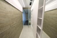 a hallway with wooden floors and a wall with shelves at Sky Garden Suites in Adana