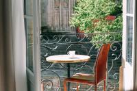 a table and a chair on a balcony at LOLA Boutique Hôtel - Bordeaux Centre in Bordeaux