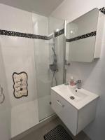 a white bathroom with a sink and a shower at Les Pieds dans le Sable in Le Grau-du-Roi
