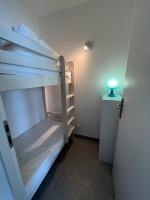 a room with two bunk beds next to a door at Les Pieds dans le Sable in Le Grau-du-Roi