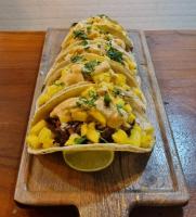 two tacos on a cutting board with a lime at Hotel Boutique Victoria in Moyogalpa