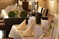 una fila de mesas con menús blancos y flores. en Ringhotel Alfsee Piazza, en Rieste