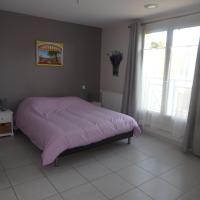 a bedroom with a bed with a pink comforter at L&#39;oustal des Fontanilles in Castelnaudary