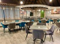 ein Restaurant mit Tischen und Stühlen in einem Raum in der Unterkunft Fumani Game Lodge in Modimolle