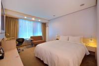 a hotel room with a large white bed and a chair at Yomi Hotel - ShuangLian MRT in Taipei