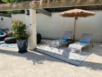 two chairs and an umbrella on a patio at Résidence Les Sources in Saint-Rémy-de-Provence