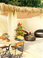 a patio with a table and chairs and some plants at Résidence Les Sources in Saint-Rémy-de-Provence