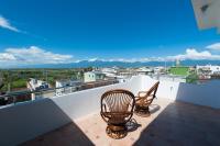 a balcony with two chairs and a view of a city at Discovery B&amp;B in Linbian