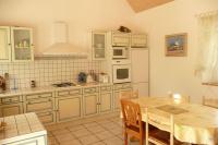 a kitchen with white cabinets and a table with a dining room at Granite stone house with fireplace, Plouguerneau in Plouguerneau