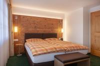 ein Schlafzimmer mit einem großen Bett mit einem hölzernen Kopfteil in der Unterkunft Hotel Jägerhof in Zermatt