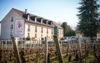 un edificio con un cartel frente a un viñedo en Hôtel-Spa Ô Rouge - Gevrey-Chambertin - Teritoria, en Gevrey-Chambertin