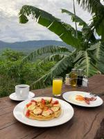 uma mesa com dois pratos de comida e sumo de laranja em Hostal Sueño Real Campestre em San Gil