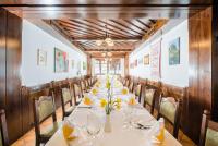 a long dining room with a long table with yellow flowers at Gasthof Siegfried Gruber in Hartmannsdorf