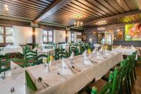 a dining room with white tables and green chairs at Gasthof Siegfried Gruber in Hartmannsdorf