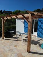 a patio with two chairs and a wooden pergola at Luciana in La Croix-Valmer